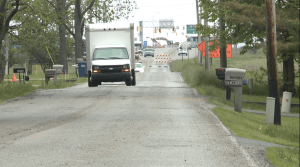 Cars and trucks can be seen bypassing the "Road Closed" sign on Whiteland Road.