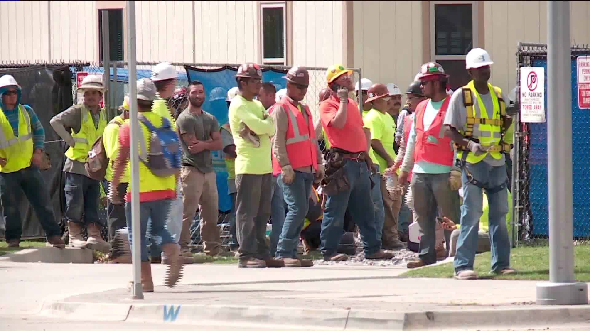 Construction workers gathered outside of work zone after scissor lift operator dies