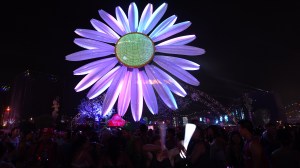 Fans gather near an electric daisy art installation during the 18th annual Electric Daisy Carnival at Las Vegas Motor Speedway on June 20, 2014 in Las Vegas, Nevada. (Credit: Ethan Miller/Getty Images)