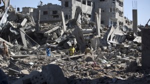 Palestinians walk amid the rubble of destroyed buildings and homes in the Shejaiya residential district of Gaza City on Saturday, July 26, 2014, as families returned to find their homes ground into rubble by relentless Israeli tank fire and air strikes. The death toll in Gaza soared to more than 1,000 as bodies were pulled from the rubble during a 12-hour truce top diplomats urged Israel and Hamas to extend. AFP PHOTO/MAHMUD HAMS (Credit: Mahmud Hams/AFP/Getty Images)