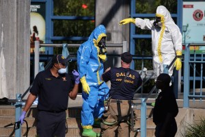 First responders wear full biohazard suits while responding to the report of a woman with Ebola-like symptoms at the Dallas Area Rapid Transit White Rock Station Oct. 18, 2014, in Dallas. The woman reportedly lives in the same apartment complex as Thomas Eric Duncan, the Liberian who was the first patient diagnosed with Ebola in the United States, and who died on October 8. (Credit: Chip Somodevilla/Getty Images)