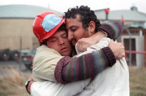 Two search and rescue workers embrace after rescuing a man from a collapsed freeway structure in Oakland on Oct. 21, 1989. (Credit: CHRIS WILKINS/AFP/Getty Images)