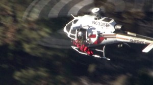 A person injured in the crash of a small plane in Big Bear is airlifted from the wreckage on Oct. 16, 2014. (Credit: KTLA)