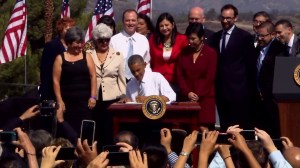 Backed by supporters of the designation, Obama signs a proclamation creating the San Gabriel Mountains National Monument on Oct. 10, 2014. (Credit: CNN)