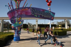 Pedestrians walk near the entrance to Disneyland Resort on Feb. 19, 2009, in Anaheim. (Credit: David McNew/Getty Images)