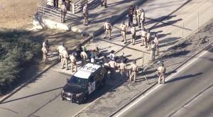 California Highway Patrol officers stood near a group of seated protesters on the 101 Freeway in Los Angeles on Wednesday, Nov. 26, 2014.  (Credit: KTLA)