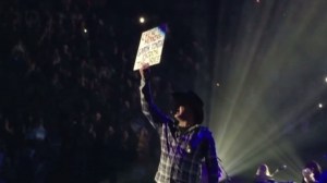 Garth Brooks is seen holding a sign from a fan at a Minneapolis show on Nov. 7, 2014, that read, chemo this morning, Garth tonight, enjoying ‘the dance.’” (Credit: CNN) 