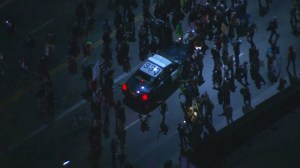 Protesters briefly surrounded a CHP patrol car on Jefferson Boulevard on Nov. 25, 2014. (Credit: KTLA)