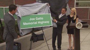 Assemblyman Mike Gatto unveils a sign at a dedication ceremony for the Joseph Gatto Memorial Highway on Nov. 12, 2014. (Credit: KTLA)