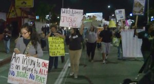 Dozens of people march down Martin Luther King Jr. Boulevard Monday protesting the grand jury decision in the Michael Brown shooting case. (Credit: KTLA)