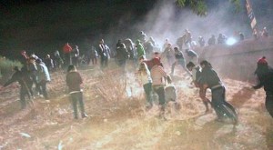 Protesters scramble up an embankment near Pico Boulevard to get onto the 110 Freeway. (Credit: Nerissa Knight)