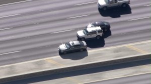 The driver of a speeding SUV squeezes between two cars on the southbound 101 Freeway during a pursuit on Nov. 24, 2014. (Credit: KTLA)