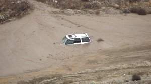 An unoccupied SUV was submerged in mud in Gilman Springs on Thursday, Dec. 4, 2014. (Credit: KTLA)