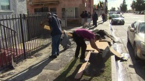 People were cleaning up after residents described a "tornado" ripping the roof off a house in South L.A. on Dec. 12, 2014. (Credit: KTLA)