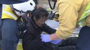 Firefighter and paramedics help a woman rescued from the L.A. River on Dec. 12, 2014. (Credit: KTLA)