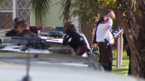 Police surround a home in Mid-City near a triple shooting that left three people in critical condition on Wednesday, Dec. 17, 2014. (Credit: KTLA)