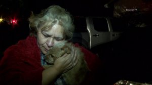 Vera Mendez cradles her dog Foxy, who was credited with saving Mendez's family from a fire in Santa Ana on Jan. 21, 2015. (Credit: OnScene TV)