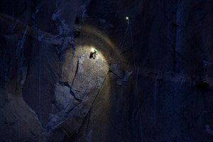 Kevin Jorgeson (center, in green) navigating Pitch 15 while Tommy Caldwell (far right, in yellow) belays on Jan. 6, 2015. Multiple cameramen hang on ropes taking photos and video. (Credit: Tome Evans / elcapreport.com)