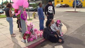 Reanna Goss' mother, sitting on curb in middle, was among those mourning Jan. 28, 2015, at the site where Goss was killed. (Credit: KTLA)