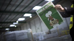 A person reads the forthcoming edition of the weekly newspaper Charlie Hebdo, on Jan. 13, 2015, in Villabe, south of Paris, a week after two jihadist gunmen stormed the Paris offices of the satirical magazine, killing 12 people including some of the country's best-known cartoonists. Its cover features the prophet with a tear in his eye, holding a 'Je Suis Charlie' sign under the headline "All is forgiven." (Credit: MARTIN BUREAU/AFP/Getty Images)