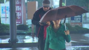 A man and woman are seen crossing a street in the rain on Saturday, Jan. 10, 2015. (Credit: KTLA)