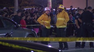 As dozens look on, firefighters and police respond to a Jan. 29, 2015, crash that killed two Banning high student siblings. (Credit: KTLA)