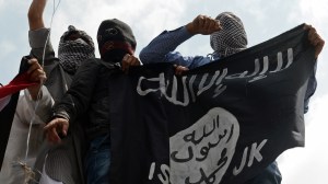 In this file photo, demonstrators hold up a flag of the Islamic State of Iraq and the Levant (ISIL) on July 18, 2014. (Credit: AFP Photo/Tauseef Mustafa) 