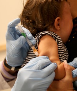 A woman is pictured holding her child as she receives a measles vaccination during a visit to the Miami Children's Hospital on June 02, 2014, in Miami, Florida. (Credit: Joe Raedle/Getty Images)