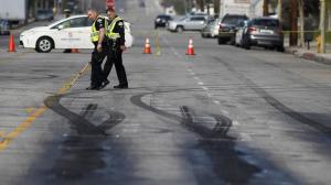 LAPD investigators survey skid marks at the scene where two pedestrians were killed by an out-of-control Ford Mustang possibly involved in street racing in Chatsworth. (Credit: Brian van der Brug / Los Angeles Times)