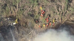 Firefighters worked in heavy brush to battle a blaze in a wash in Santa Clarita on March 23, 2015. (Credit: KTLA)