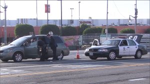 Police examine a minivan after a shooting in the Baldwin Hills area that left two men injured on Sunday, April 19, 2015. (Credit: KTLA)