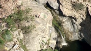 A rescuer looks down on Hermit Falls on April 8, 2015, when an 18-year-old man died after jumping into the pool below. (Credit: KTLA)