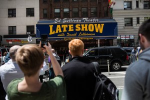 Fans of David Letterman, members of the media, security agents and passersby gather around the entrance to the Ed Sullivan Theater, where 'The Late Show with David Letterman' is filmed, on May 20, 2015, in New York City for its last episode.  (Credit: Andrew Burton/Getty Images)