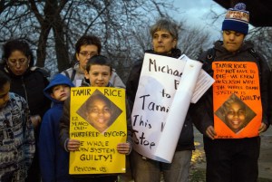 People display sigs at Cudell Commons Park in Cleveland, Ohio, Nov. 24, 2014, during a rally for Tamir Rice, a 12-year-old boy shot by police the previous day. (Credit: ORDAN GONZALEZ/AFP/Getty Images)