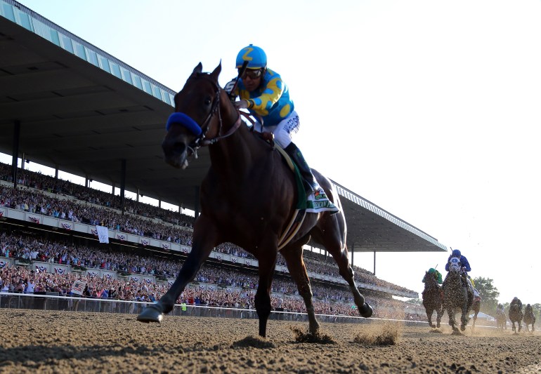 American Pharoah #5, ridden by Victor Espinoza, comes down the final stretch ahead of the field on his way to winning the 147th running of the Belmont Stakes at Belmont Park on June 6, 2015, in Elmont, New York.  (Credit: Rob Carr/Getty Images)