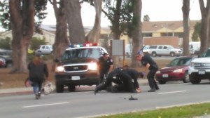 A screenshot from a cellphone video shows Salinas police officers subduing an assault suspect on Friday, June 5, 2015. (Credit: Richard Boxing/via YouTube)