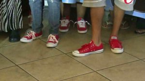 Supporters of Tavin Price wore red shoes at a June 23, 2015, news conference where police announced arrests in his killing. (Credit: KTLA)