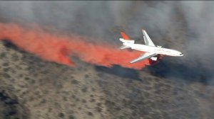 A plane makes an aerial drop in the fight against the North Fire on Friday, July 17, 2015. (Credit: KTLA)