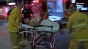 An employee at a San Fernando Valley Jack in the Box is seen being put into an ambulance after being shot during a robbery on July 12, 2015. (Credit: RMG News)