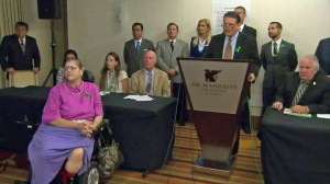 Attorney Matthew Pappas, behind the podium, speaks at a downtown L.A. news conference on July 3, 2015. His client, Marla James, is sitting in the pink shirt.