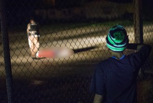 A young boy looks at a man lying in a parking lot with what appears to be gunshot wounds after a barrage of gun fire erupted along West Florrisant Street during a demonstration to mark the 1-year anniversary of the shooting of Michael Brown on Aug. 9, 2015, in Ferguson, Missouri. (Credit: Scott Olson/Getty Images)