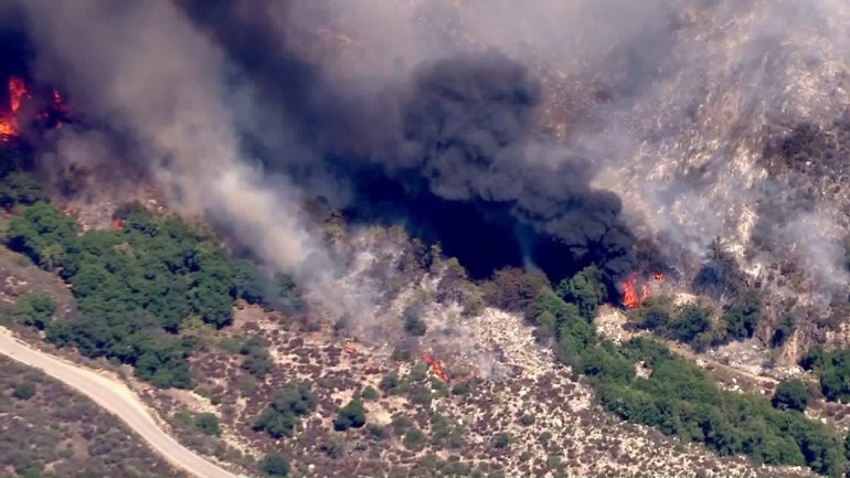 The Cabin Fire send black smoke above the mountains on Aug. 14, 2015, above Azusa. (Credit: KTLA)