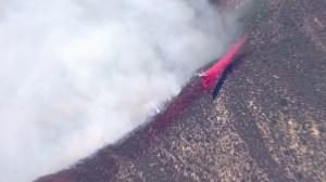 A plane drops fire retardant on the Cabin Fire on Aug. 14, 2015. (Credit: KTLA)