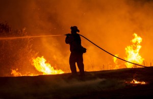 Firefighter Joe Darr douses flames of the Rocky Fire along Highway 20 near Clearlake, California, on Aug. 2, 2015. (Credit: Josh Edelson/AFP/Getty Images)