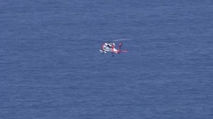 A U.S. Coast Guard helicopter searches for a missing fisherman off Dana Point on Aug. 4, 2015. (Credit: KTLA)