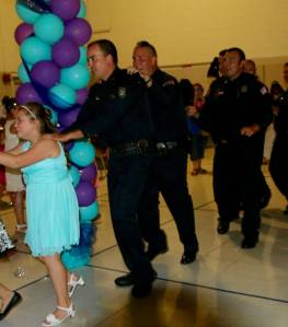 The daughter of Tim Warren, a fallen Memphis policeman, is seen with officers who stepped in to escort her to a father-daughter dance. (Credit: Memphis Police Department)