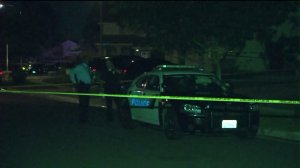 Police are seen outside a Corona home where two male victims were killed and another one was injured on Thursday, Sept. 17, 2015. (Credit: KTLA)