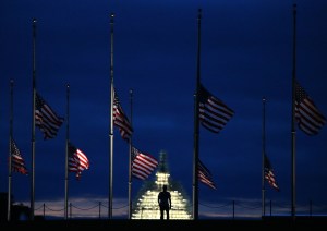 A man walks past a row of American flags that have been lowered to half staff on the Washington Monument grounds, near the US Capitol on Sept. 11, 2015, in Washington, D.C. (Credit: Mark Wilson/Getty Images)