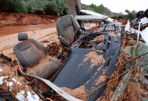 The twisted wreckage  of one of two vans that were washed away in a flash flood with women and children inside rest on the bank of Short Creek on Sept. 15, 2015, in Hildale, Utah. (Credit: George Frey/Getty Images)