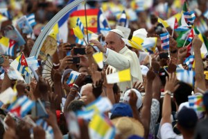 People wave Cuban and Papal flags as Pope Francis passes by as he arrives to perform Mass on Sept. 20, 2015, in Revolution Square in Havana, Cuba. (Credit: Carl Court/Getty Images)